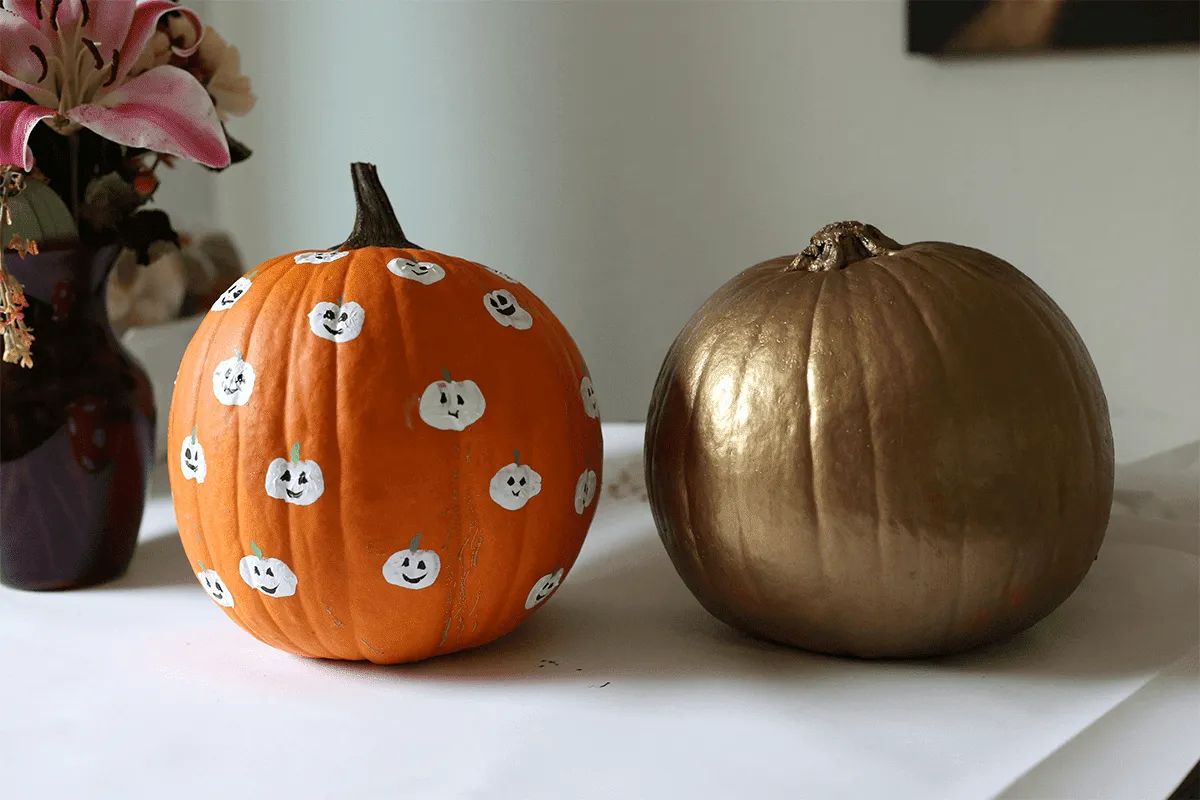 Two pumpkins on a table—one painted gold, the other orange with small white pumpkins—add festive charm to MorningStar Senior Living Hillsboro. A vase with pink flowers completes this inviting retirement living scene.
